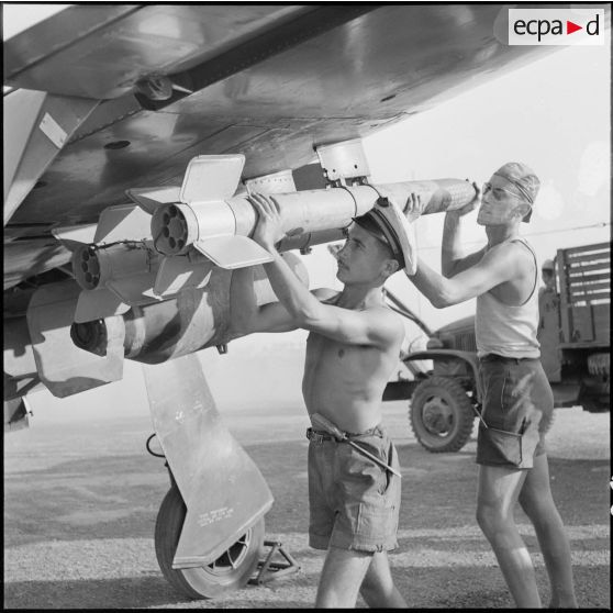 Des armuriers installent des roquettes HVAR de 5 pouces sous les ailes d’un Bearcat. [description provisoire]