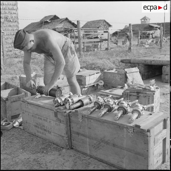 8 Le sergent Gaston Darry, l'armurier du groupe, prépare des munitions pour l'approvisionnement  d'un avion Bearcat F8F. [description provisoire]