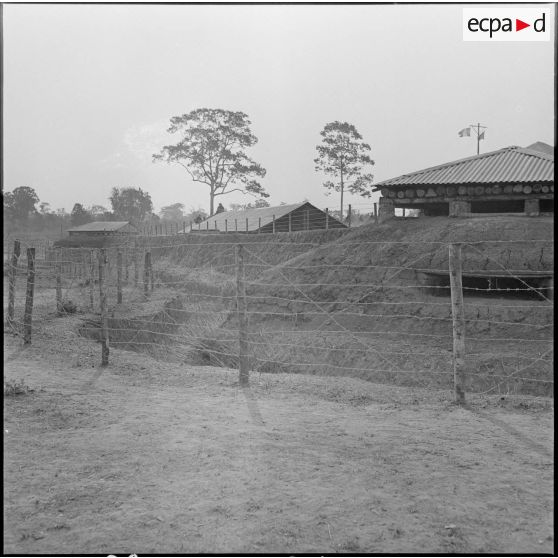4 Poste de Damber : blockhaus d'angle protégé par des barbelés (plan moyen). [description provisoire]