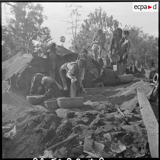 8 à 10  Des habitants tentent de retrouver et récupérer quelques objets ou biens dans les décombres. [description provisoire]