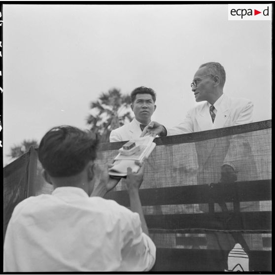 5 M. Chan Nak (à droite) -conseiller de la Couronne- remet un cadeau à chaque PIM libéré. M. Nginh Nippa, à ses côtés. [description provisoire]