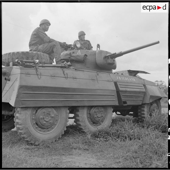 13 Automitrailleuse LAC M8 (Light Armoured Car), vue de profil, placée en surveillance pendant l'exécution  du tir. [description provisoire]