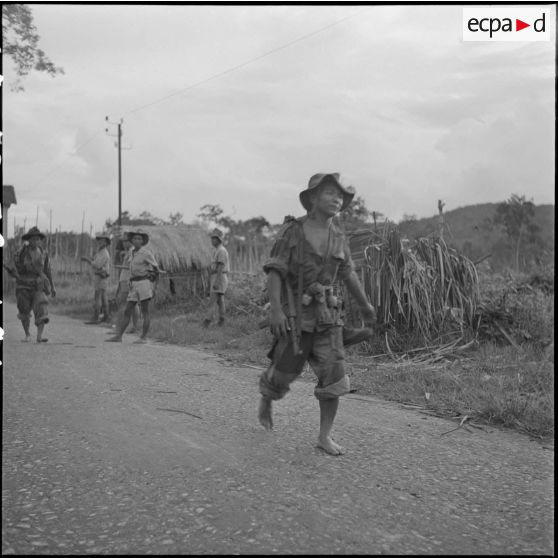 4 Soldats (2e compagnie du Bataillon parachutiste khmer) sur la route au retour d'une pénible randonnée en brousse. [description provisoire]