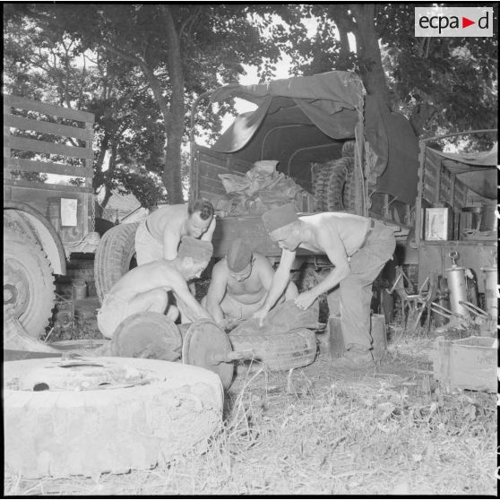 11 à 12  Réparation d'un véhicule par des militaires de la CMRLE. [description provisoire]