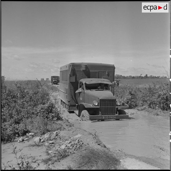 4 à 5 Camion franchissant une dérivation inondée par les pluies. [description provisoire]