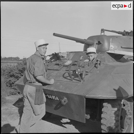 7 Plan rapproché sur une AM LAC M8 ; un légionnaire sort la tête de la tourelle, un autre est appuyé sur la partie avant [description provisoire]