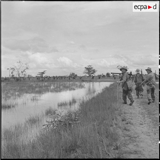 5 Les soldats de la 11e compagnie du 3/RMC (3e bataillon du Régiment Mixte du Cambodge)  longent la rizière inondée. [description provisoire]