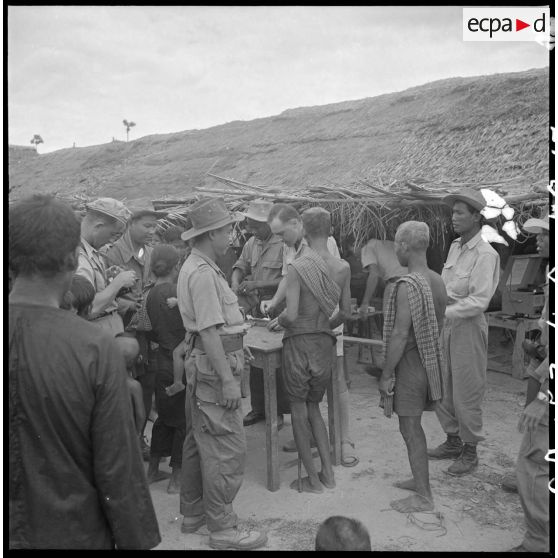 13 à 16 Soins dispensés à la population civile par le médecin-lieutenant Outters, médecin du bataillon (2/6e RIC). [description provisoire]