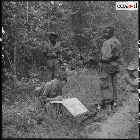 6 Le lieutenant Sansue, commandant la 6e compagnie du 2/6e RIC, fait le point sur la carte, entouré de 2 militaires. [description provisoire]