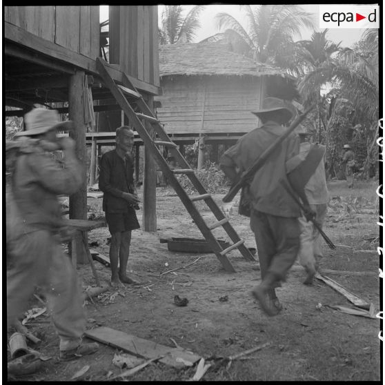 9 Vérification des papiers d'identité de 2 habitants par le lieutenant Sansue, commandant la 6e compagnie du 2/6e RIC. [description provisoire]