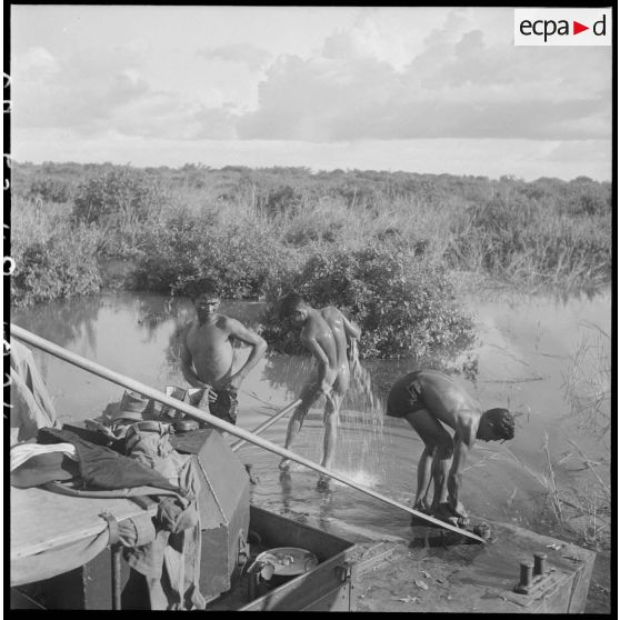 24 Trois militaires (du 2/RMC ou du 5e RSM) font leur toilette dans l'eau de la rivière. [description provisoire]