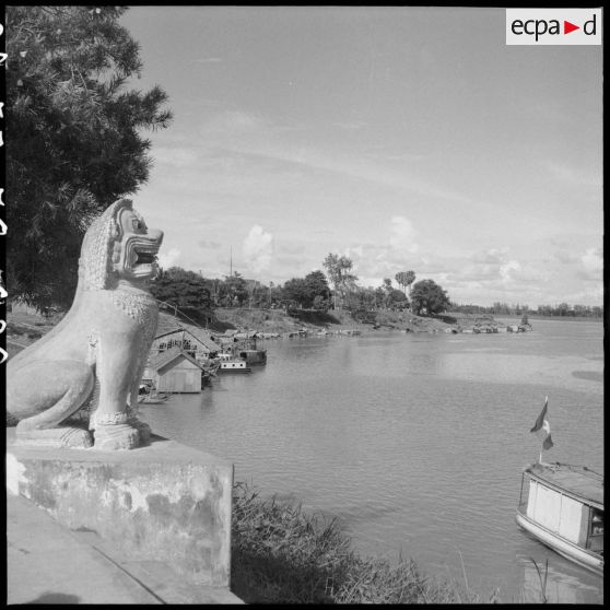 26 Habitations construites sur une rive du Mékong à Kompong Cham ; au premier plan, un lion sculpté. [description provisoire]