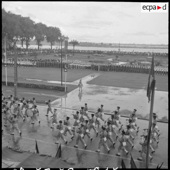 15 Plan d'ensemble en plongée du défilé de la musique et des troupes rassemblées (en arrière-plan). [description provisoire]