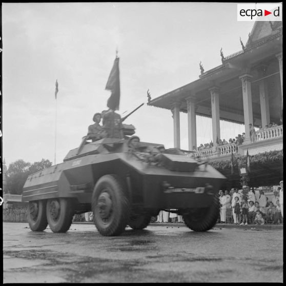18 Plan moyen sur une automitrailleuse LAC (Light Armoured Car) M8 passant devant le palais royal, dans le cadre du défi [description provisoire]