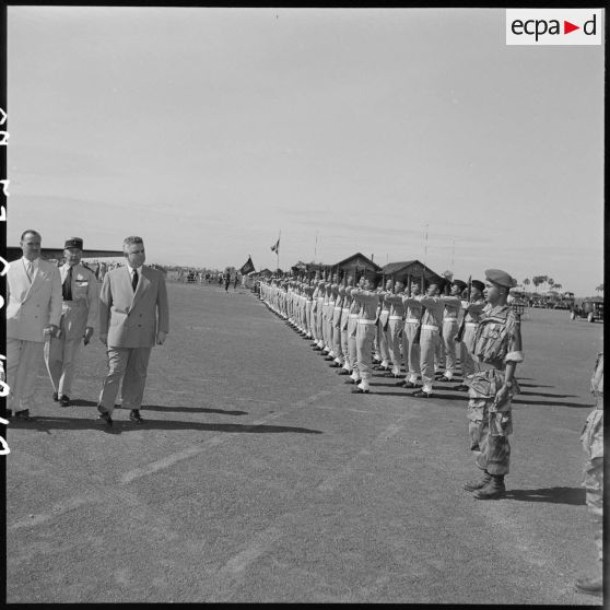 18 Arrivée de M. Jacquet à l'aérodrome de Dalat. Revue des troupes par M. Jacquet, une autorité militaire et civile. [description provisoire]