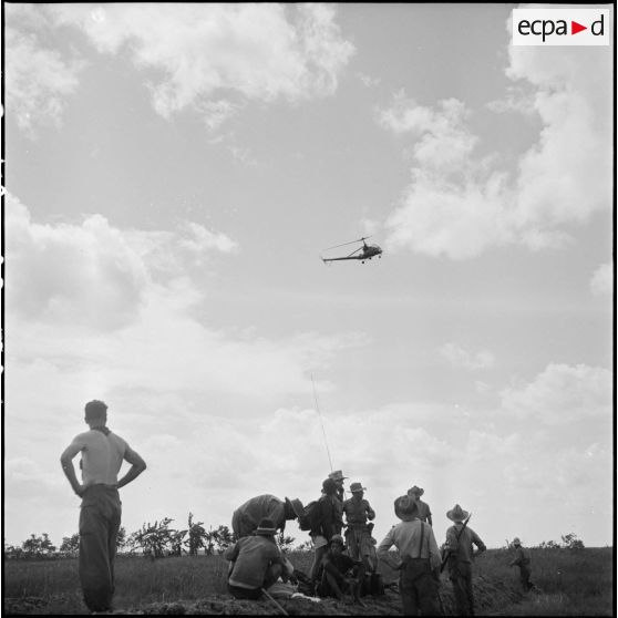 Arrivée d'un hélicoptère sanitaire Hiller pour évacuer un blessé au cours de l'opération Tourbillon VII. [description provisoire]
