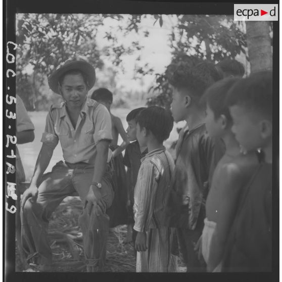 Des enfants interrogent un lieutenant commandant la 3e compagnie du 13e bataillon vietnamien de passage dans un hameau. [description provisoire]