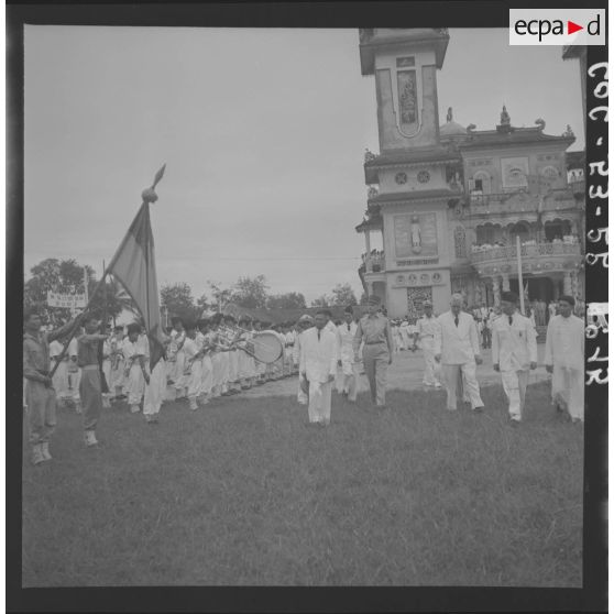 Passage en revue des troupes caodaïstes, par le président Tam et du Haut-Commissaire Gautier, devant le temple de Tay Ninh.