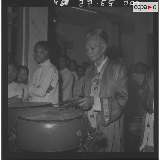 Croyant caodaïste jouant du tambourin, au temple de Tay Ninh, durant la fête du Palais du Dieu Tri.