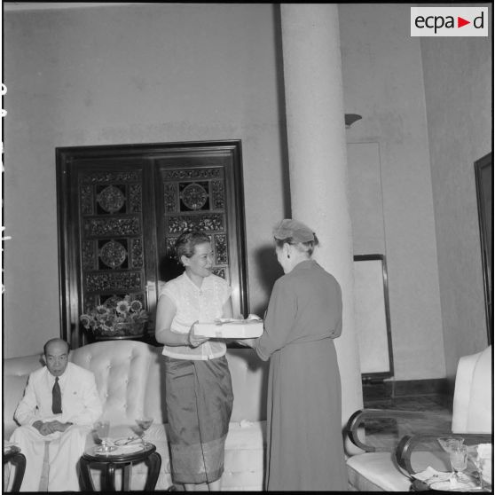 18 à 19 La reine du Cambodge remet un cadeau souvenir à Madame Paul Ely. [description provisoire]
