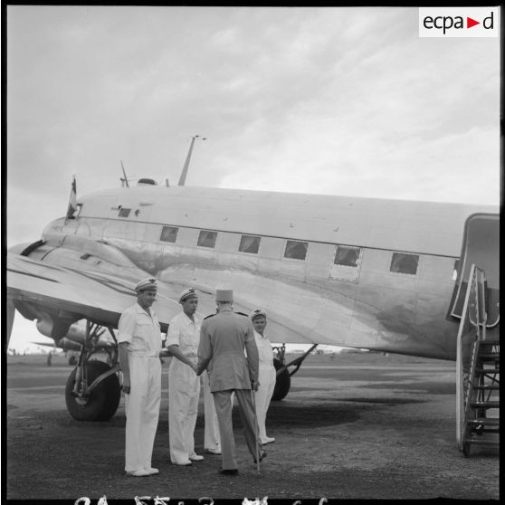 66 Le général Ely, de dos, avec 3 officiers (?) de l'armée de l'Air (?) evant un avion Douglas C-47B Skytrain. [description provisoire]