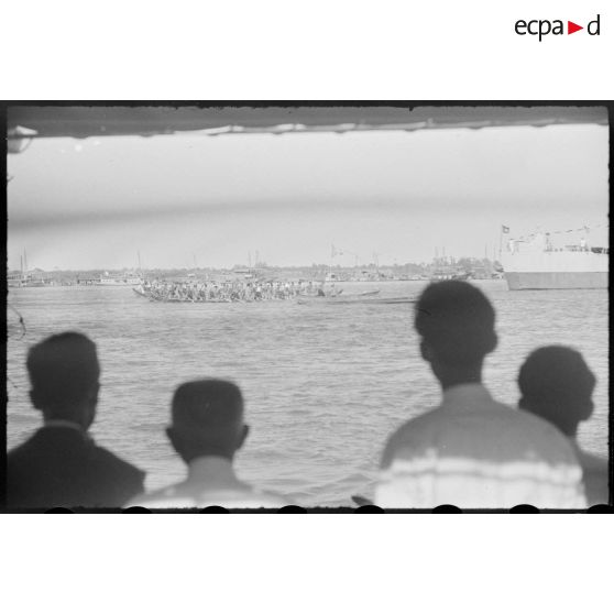 35 Les pirogues de course rejoignent le point de départ (plan d'ensemble au second plan). [description provisoire]