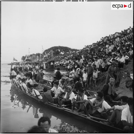 14 Plan rapproché sur une pirogue à proximité de la foule massée sur la berge du Mékong. [description provisoire]