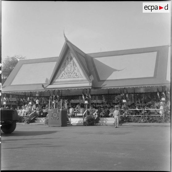 12 Plan d'ensemble de la tribune officielle d'où les personnalités assistent au défilé du cortège royal. [description provisoire]