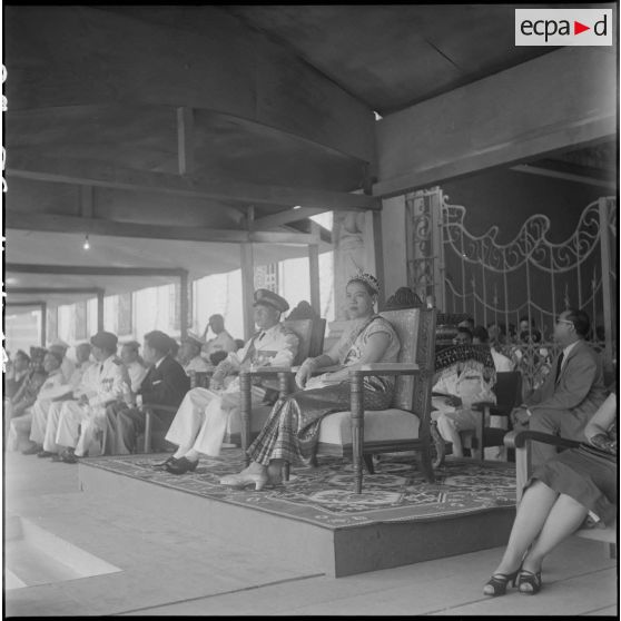 17 Plan moyen sur la tribune officielle où siègent le roi Suramarit et la reine Kossamak du Cambodge. [description provisoire]