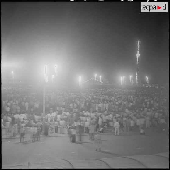 8 Plan d'ensemble de la foule massée sur l'esplanade du palais royal pour assister au feu d'artifice. [description provisoire]