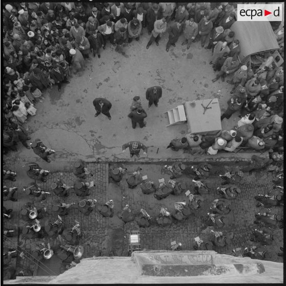 Plusieurs centaines de personnes entourent le podium où des orateurs prennent tour à tour la parole.