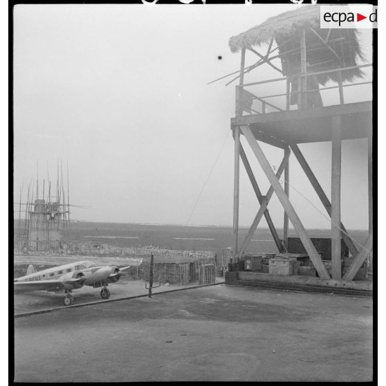Un avion transporteur au pied d’une tour de garde de l’aérodrome de Hué.