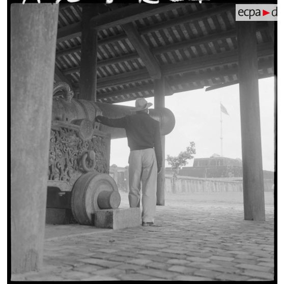Soldat de l’armée nationale vietnamienne posant à côté d’un canon dans la citadelle impériale de Hué.