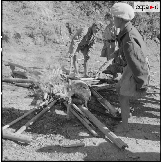  Au cantonnement, un feu a été allumé par des soldats de l'Armée nationale laotienne pour faire cuire un cochon.