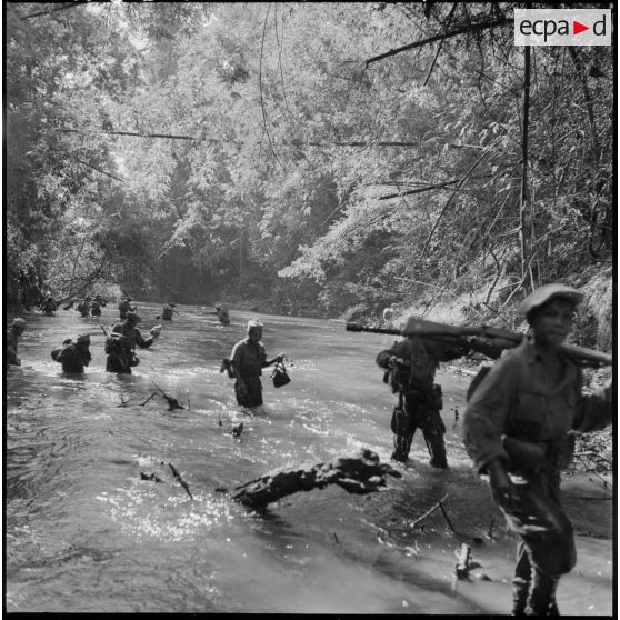 Passage d'un petit ruisseau très encaissé par des chasseurs du 2e bataillon de chasseurs laotiens (2e BCL).