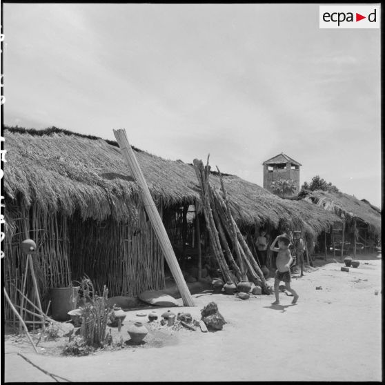 Enfants devant une paillote du village fortifié de Cu Loi.