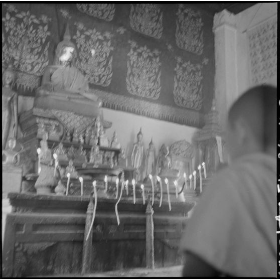 Bonze du Vat Khili en prière devant l'autel principal, à Luang Prabang.