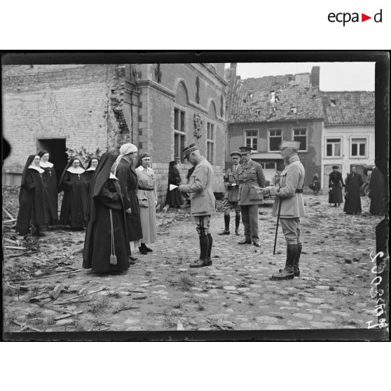 Hazebrouck, remise de la croix de guerre par le général de la Guiche à madame la duchesse de Sutherland, à madame Lionville et à une soeur de l'hôpital. Le général lit la citation. [légende d'origine]