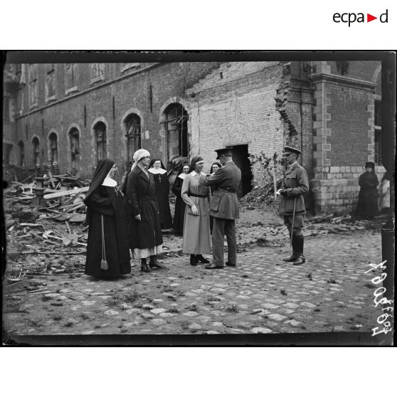 Hazebrouck, remise de la croix de guerre par le général de la Guiche à madame la duchesse de Sutherland, à madame Lionville et à une soeur de l'hôpital. Le général lit la citation. [légende d'origine]