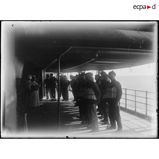 En mer rouge. Distribution de ceintures de sauvetage. [légende d'origine]