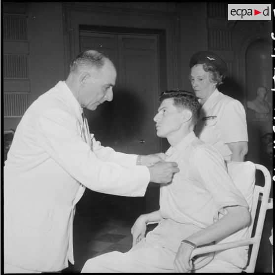 Le général de Lattre de Tassigny décore le photographe Georges Liron, blessé en opération.