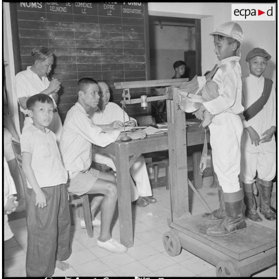 Les jeunes jockeys sont pesés avec leur selle avant une course à l'hippodrome de Phu Tho à Saigon.