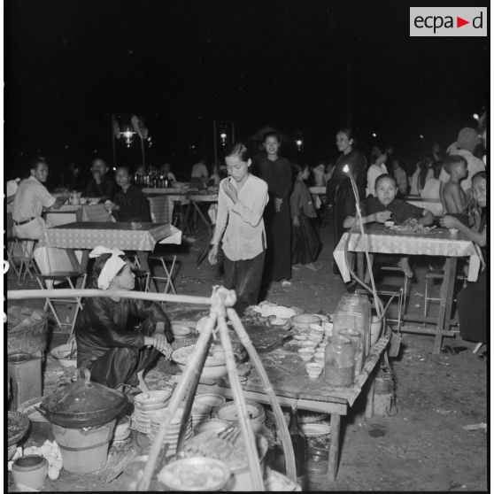 Des vietnamiens dînent la nuit près d'une échoppe dans une rue de Saigon.