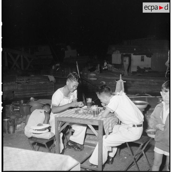Des marins vietnamiens attablés dans une échoppe de rue à Saigon.