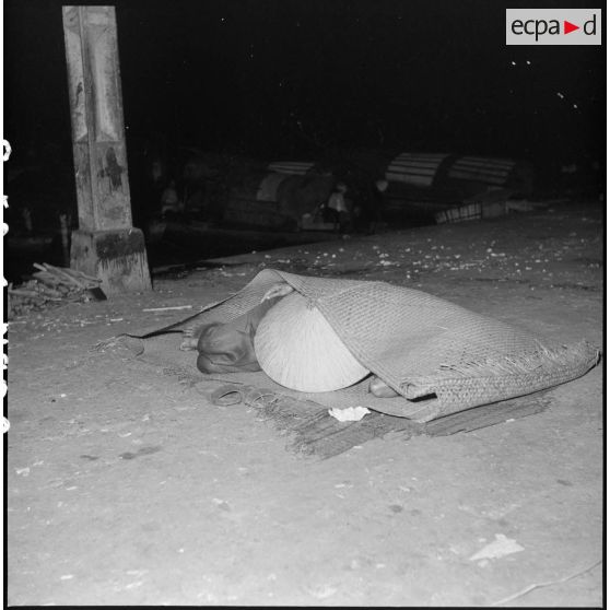 Vietnamien dormant dans une paillasse dans une rue de Saigon.
