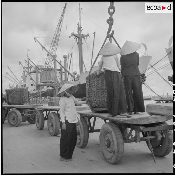 Déchargement de marchandises depuis les navires accostés au port de Saigon et transportés par des Vietnamiennes.