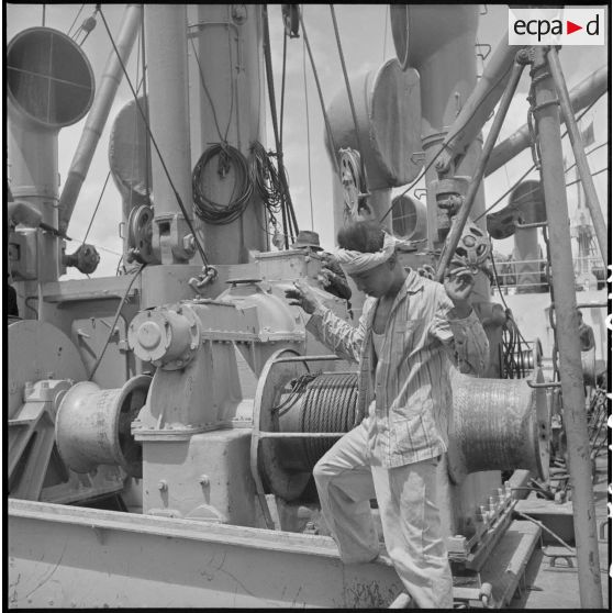Contrôle d'un treuil par un Vietnamien à bord d'un navire au cours du déchargement de marchandises au port de Saigon.