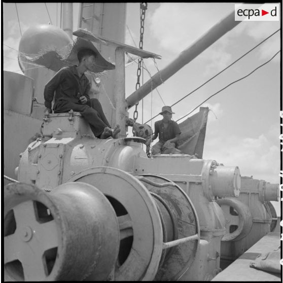 Contrôle d'un treuil par un Vietnamien à bord d'un navire au cours du déchargement de marchandises au port de Saigon.