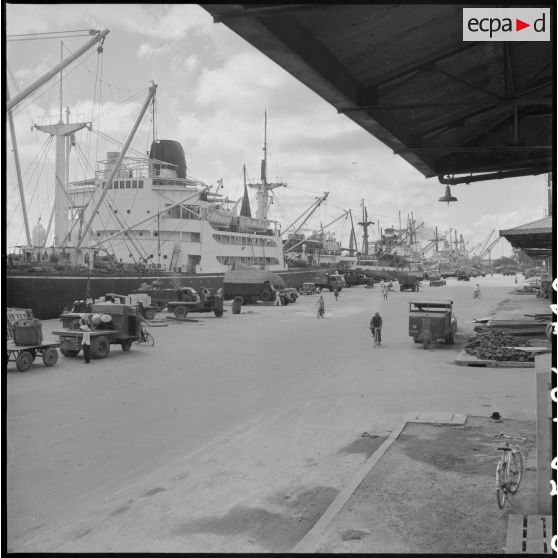 Activités et déchargement de marchandises des navires accostés au port de Saigon.