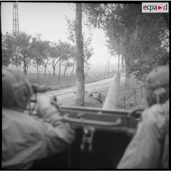 Un tireur couché et un char TD M10 du Régiment blindé de fusiliers marins (RBFM) sont en position de combat sur une route.